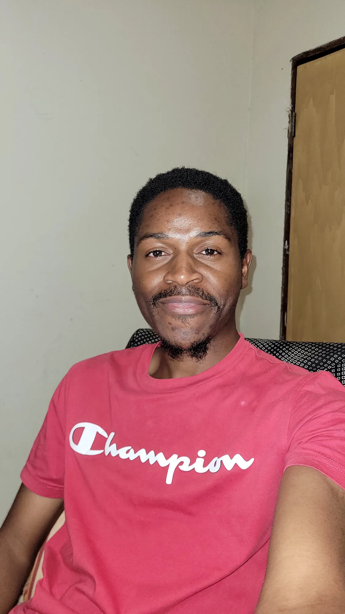 A black man smiling - Person with Orange T-Shirt - Akas Jeremy